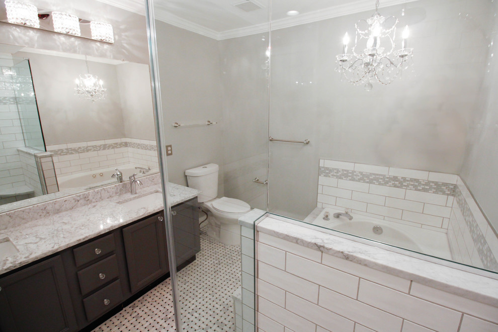 Design ideas for a mid-sized traditional master bathroom in New York with flat-panel cabinets, grey cabinets, a drop-in tub, a corner shower, an urinal, white tile, ceramic tile, grey walls, mosaic tile floors, an undermount sink, marble benchtops, white floor and a hinged shower door.