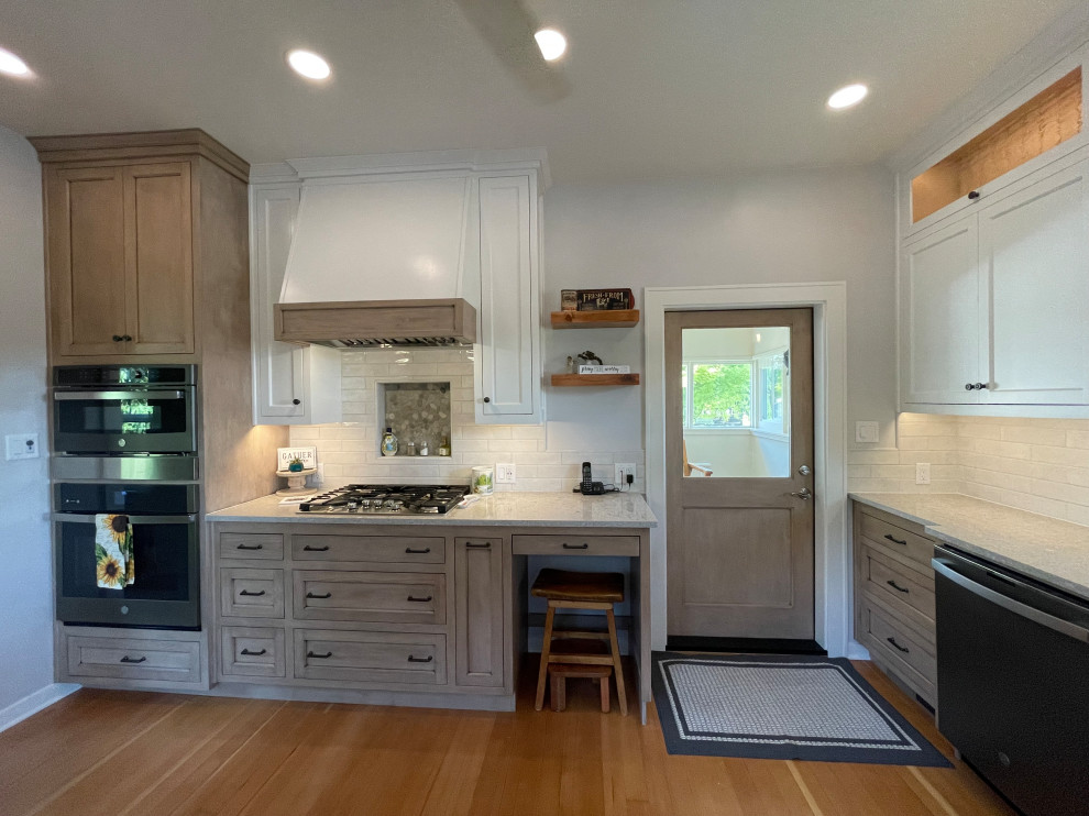 This is an example of a large country u-shaped separate kitchen in Other with a farmhouse sink, shaker cabinets, grey cabinets, quartz benchtops, white splashback, subway tile splashback, black appliances, medium hardwood floors, no island, brown floor and beige benchtop.