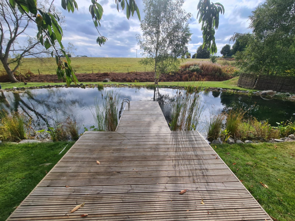 Ispirazione per un laghetto da giardino minimal esposto in pieno sole dietro casa in estate con sassi di fiume