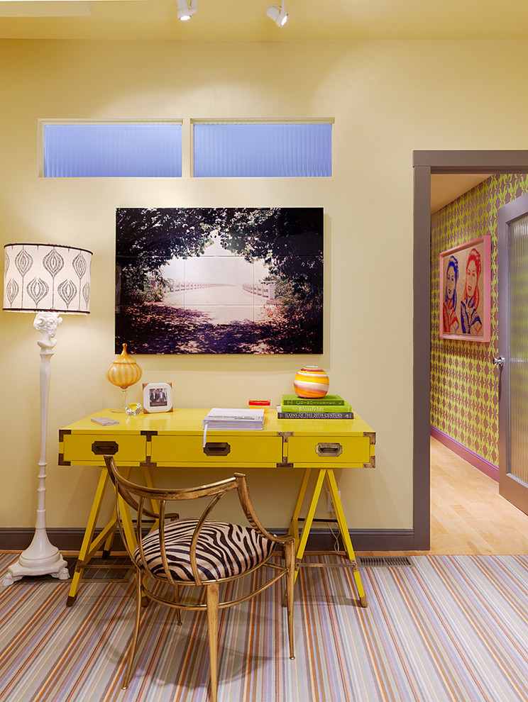 This is an example of an eclectic home office in San Francisco with yellow walls and a freestanding desk.