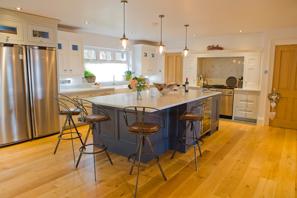 Inspiration for a medium sized traditional kitchen with a submerged sink, beaded cabinets, quartz worktops, stone slab splashback, light hardwood flooring and an island.