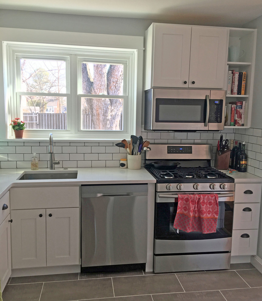 Inspiration for a small transitional u-shaped kitchen in DC Metro with an undermount sink, shaker cabinets, white cabinets, quartz benchtops, white splashback, ceramic splashback, stainless steel appliances, ceramic floors and a peninsula.