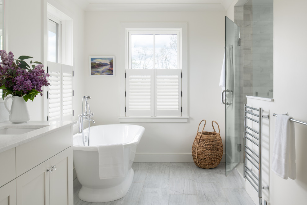 Small country master bathroom in Burlington with shaker cabinets, white cabinets, a freestanding tub, a two-piece toilet, marble, white walls, marble floors, an undermount sink, marble benchtops, white benchtops, an enclosed toilet, a double vanity and a built-in vanity.