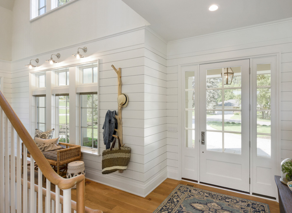 Design ideas for a beach style foyer in Minneapolis with white walls, medium hardwood floors, a single front door, a white front door and brown floor.