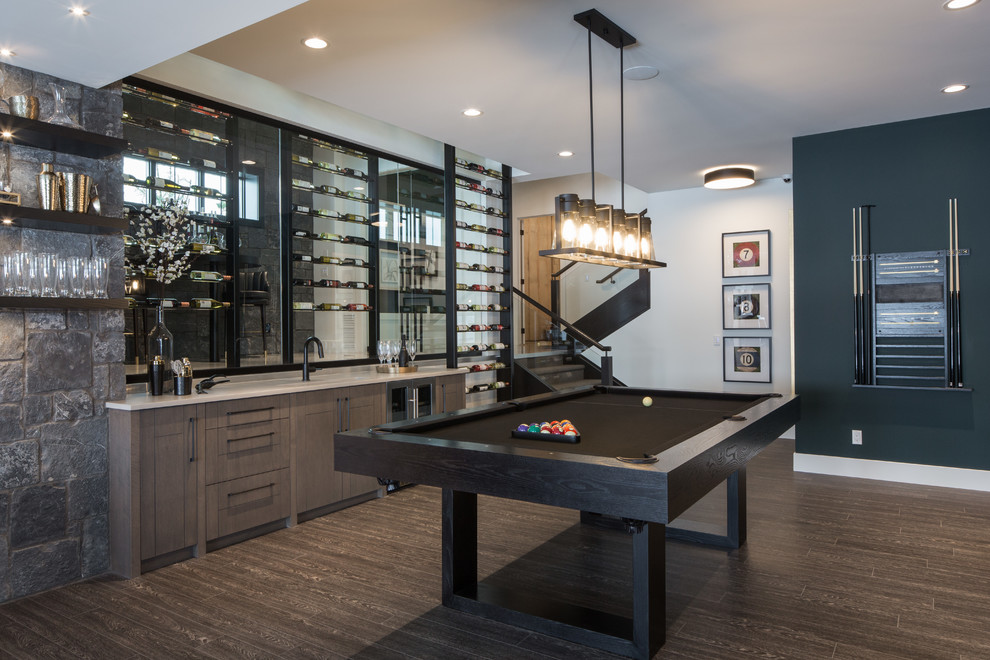 Large contemporary single-wall wet bar in Calgary with an undermount sink, flat-panel cabinets, medium wood cabinets, quartz benchtops, vinyl floors, brown floor, grey benchtop and glass sheet splashback.