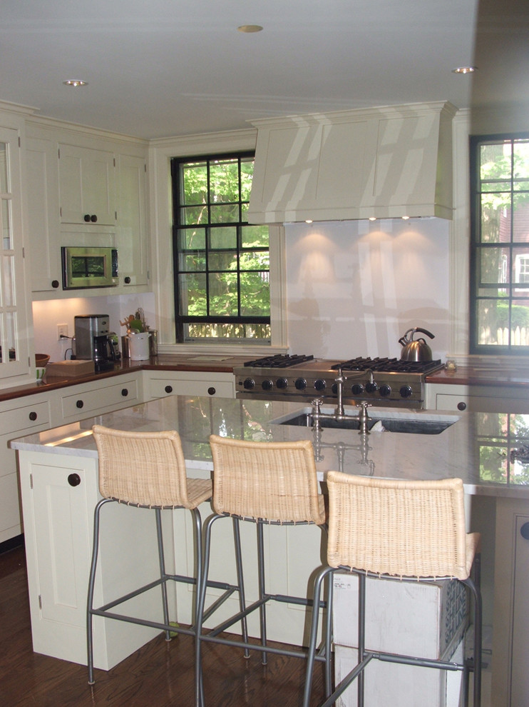 Example of a large u-shaped dark wood floor enclosed kitchen design in Boston with an undermount sink, shaker cabinets, white cabinets, marble countertops, stainless steel appliances and an island