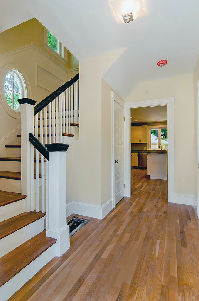 Inspiration for a small traditional hallway in Boston with yellow walls and light hardwood floors.