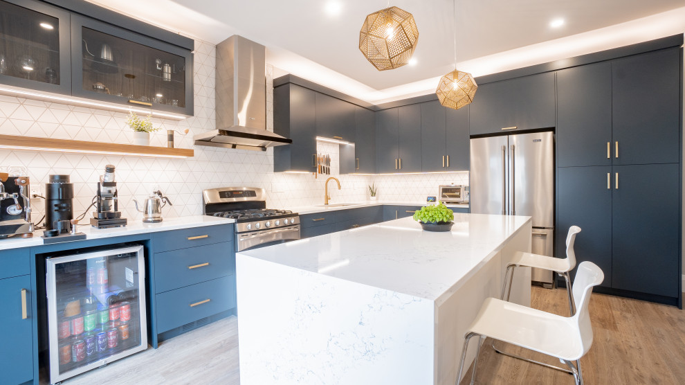 Design ideas for a modern l-shaped open plan kitchen in Toronto with flat-panel cabinets, blue cabinets, engineered stone countertops, ceramic splashback, stainless steel appliances, vinyl flooring, an island, beige floors, white worktops and white splashback.