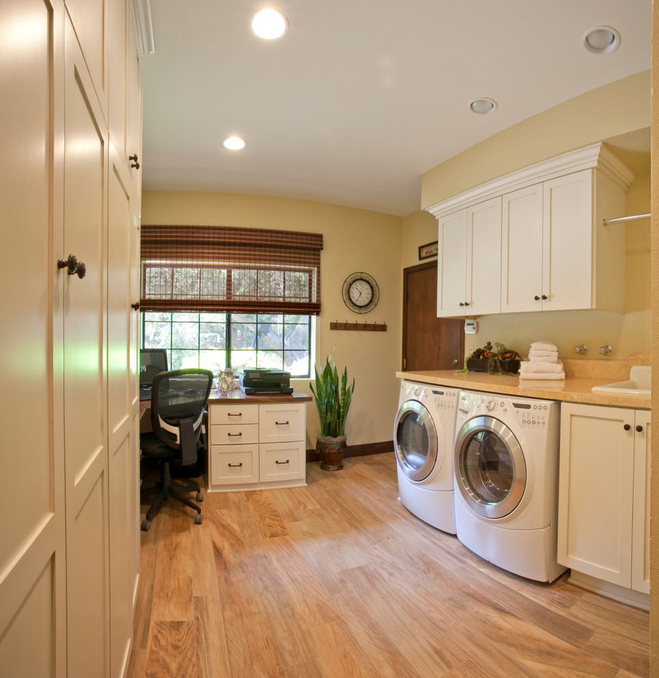 Inspiration for a mid-sized transitional galley utility room in Los Angeles with a drop-in sink, shaker cabinets, white cabinets, limestone benchtops, porcelain floors, a side-by-side washer and dryer and beige walls.