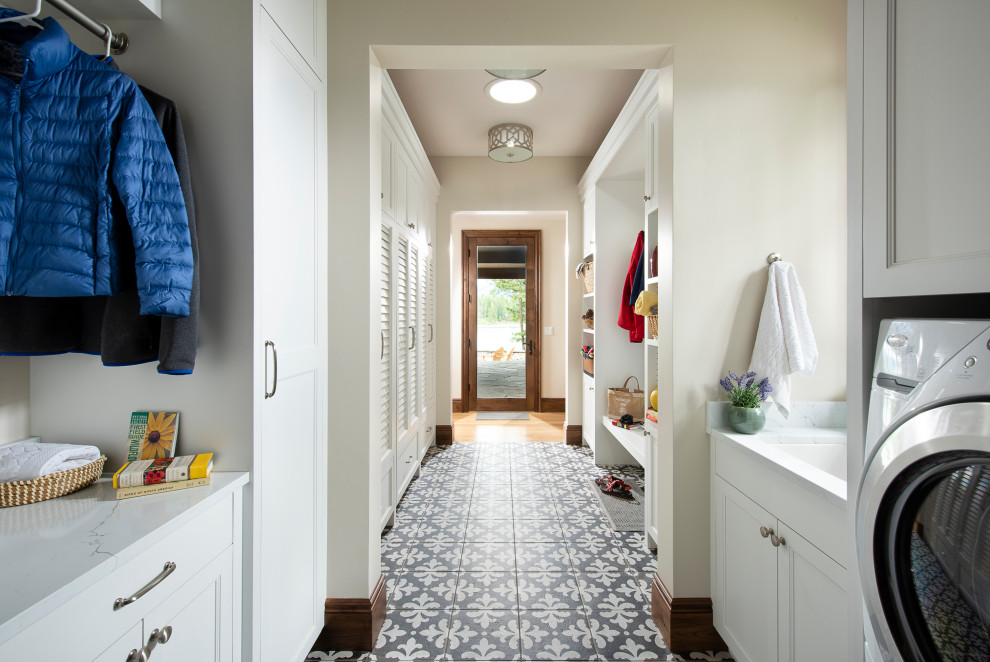 Inspiration for a large traditional galley utility room in Other with louvered cabinets, white cabinets, quartzite benchtops, white walls, porcelain floors, a side-by-side washer and dryer, black floor, white benchtop and an undermount sink.