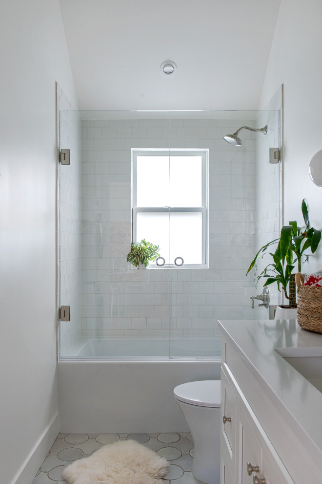 Bathroom - small modern white tile and porcelain tile ceramic tile, white floor and single-sink bathroom idea in Denver with shaker cabinets, white cabinets, a one-piece toilet, white walls, an undermount sink, quartz countertops, a hinged shower door, white countertops and a built-in vanity