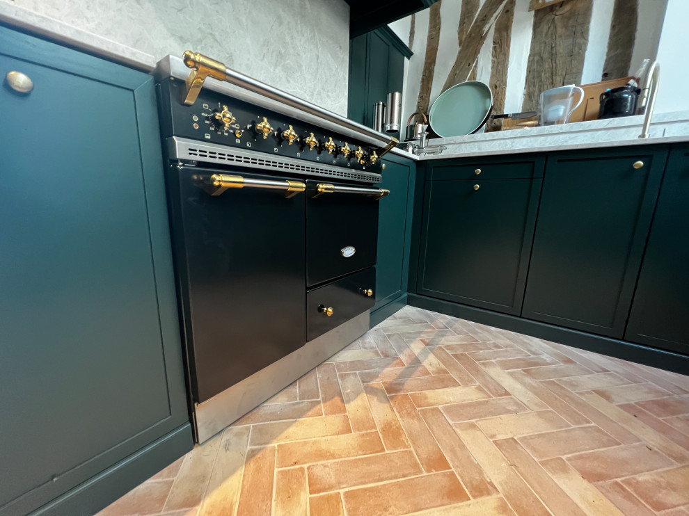 This is an example of a large arts and crafts u-shaped open plan kitchen in Other with an undermount sink, shaker cabinets, green cabinets, granite benchtops, granite splashback and terra-cotta floors.