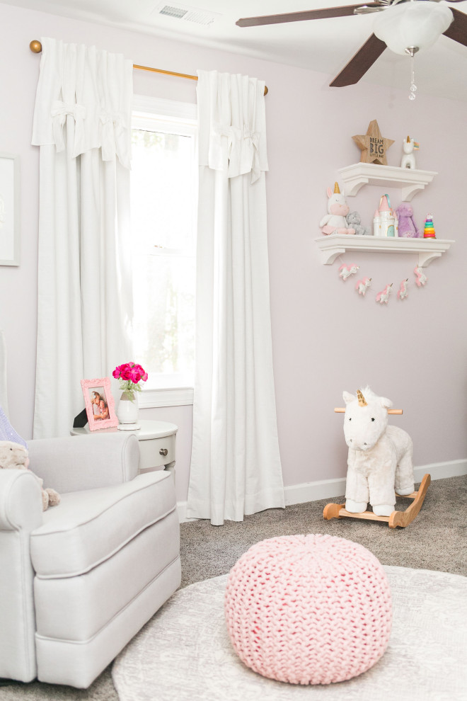 This is an example of a mid-sized transitional nursery for girls in Raleigh with carpet, pink walls and grey floor.