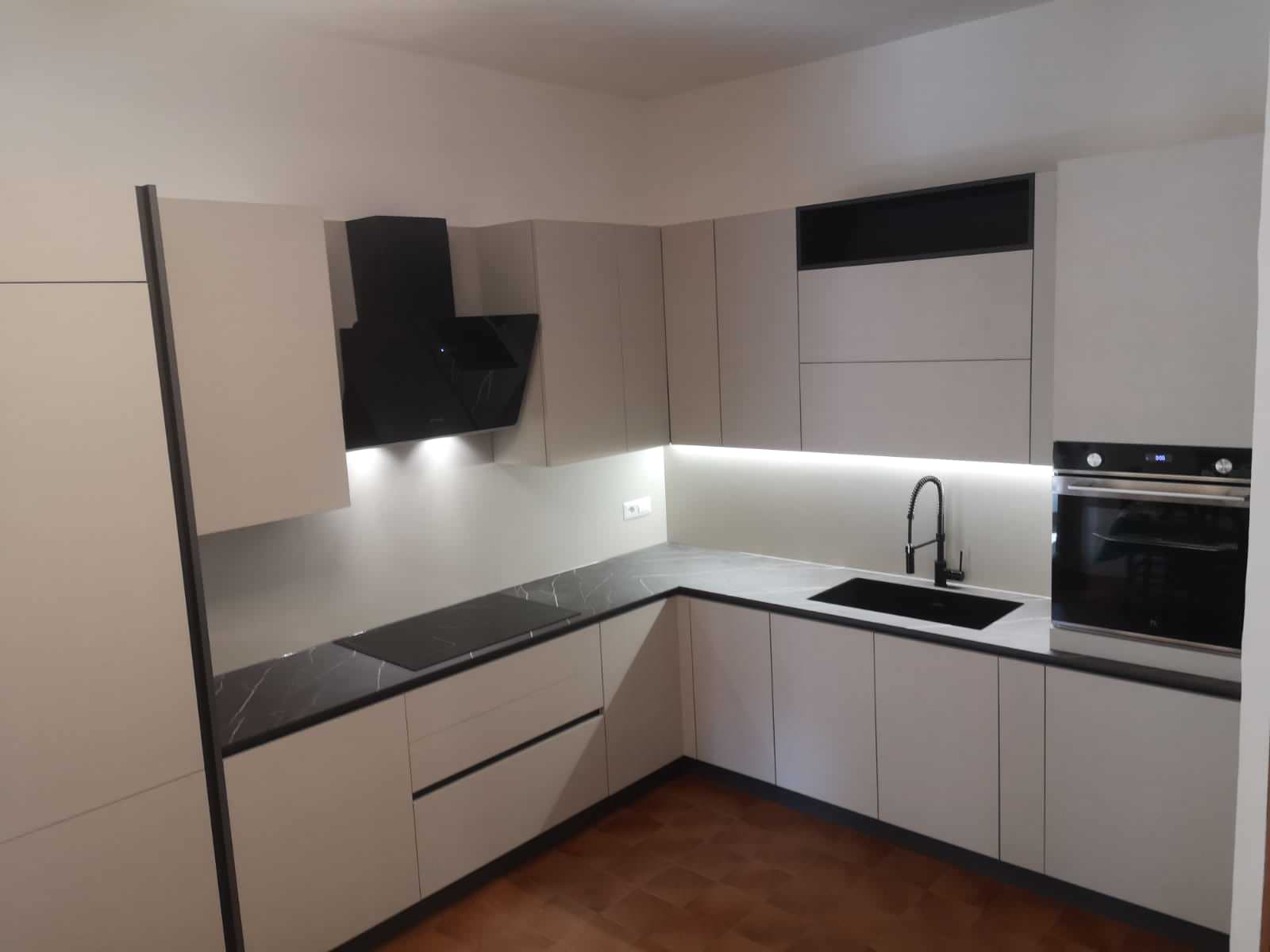 Cucina angolare Anta Beton Perla con maniglia a gola brunita. Top in HPL finitura Pulpis Dark con schienale uguale all'anta. Completano l' induzione da 77cm, il forno, la lavastoviglie e il frigo ad i