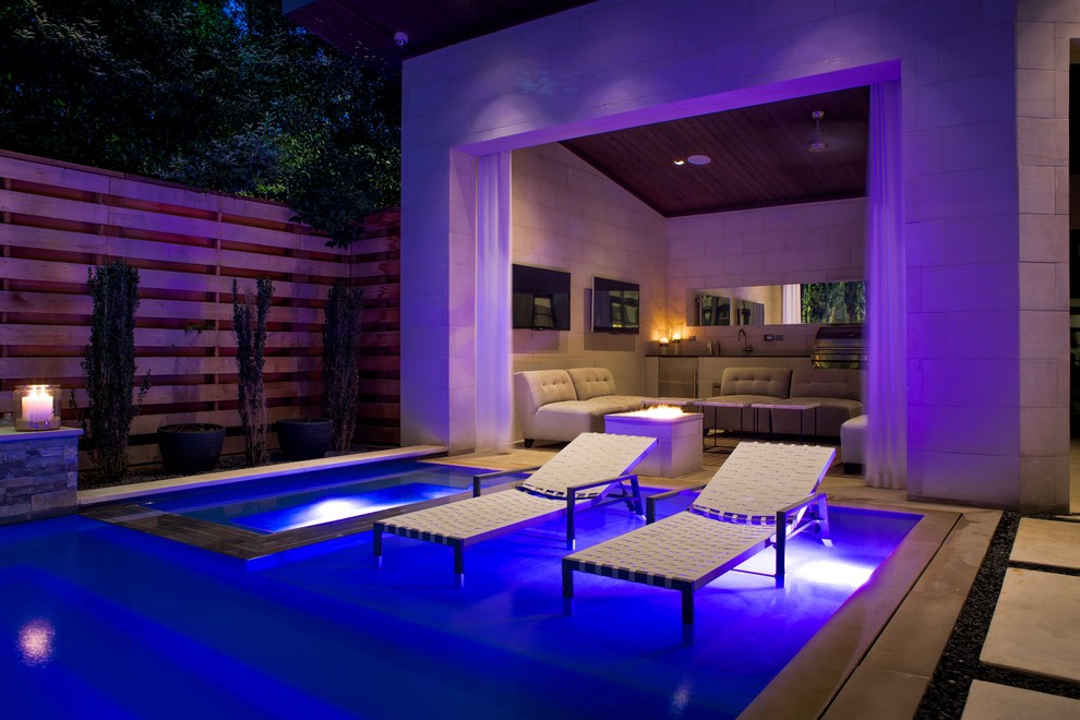 Inspiration for a mid-sized modern courtyard rectangular infinity pool in Dallas with a pool house and decking.