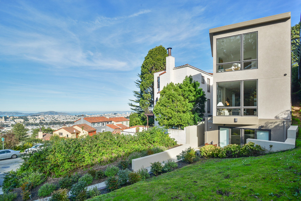 Inspiration for a large modern three-storey stucco grey house exterior in San Francisco with a flat roof.