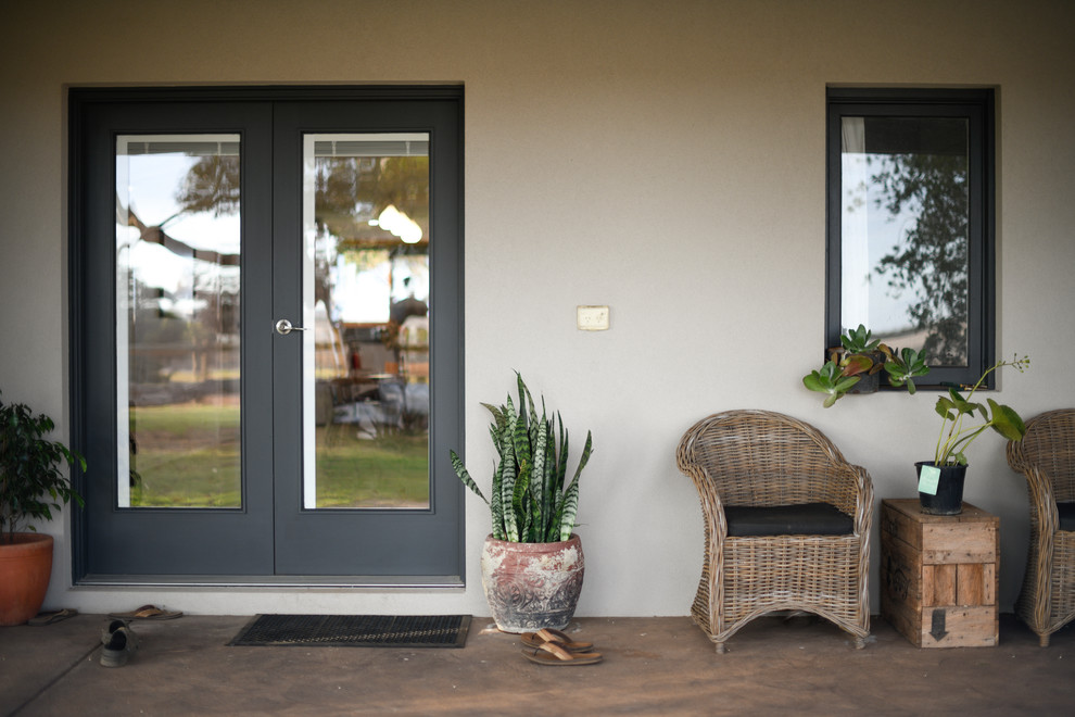 Photo of a country verandah in Other with concrete slab and a roof extension.