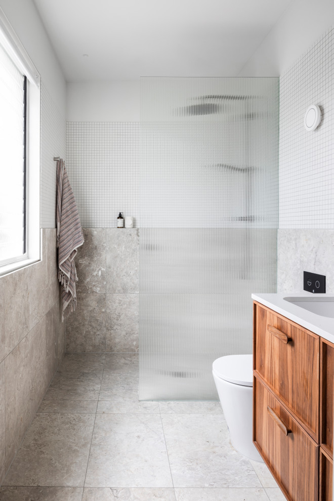 This is an example of a mid-sized contemporary bathroom in Melbourne with an open shower, subway tile and terrazzo floors.