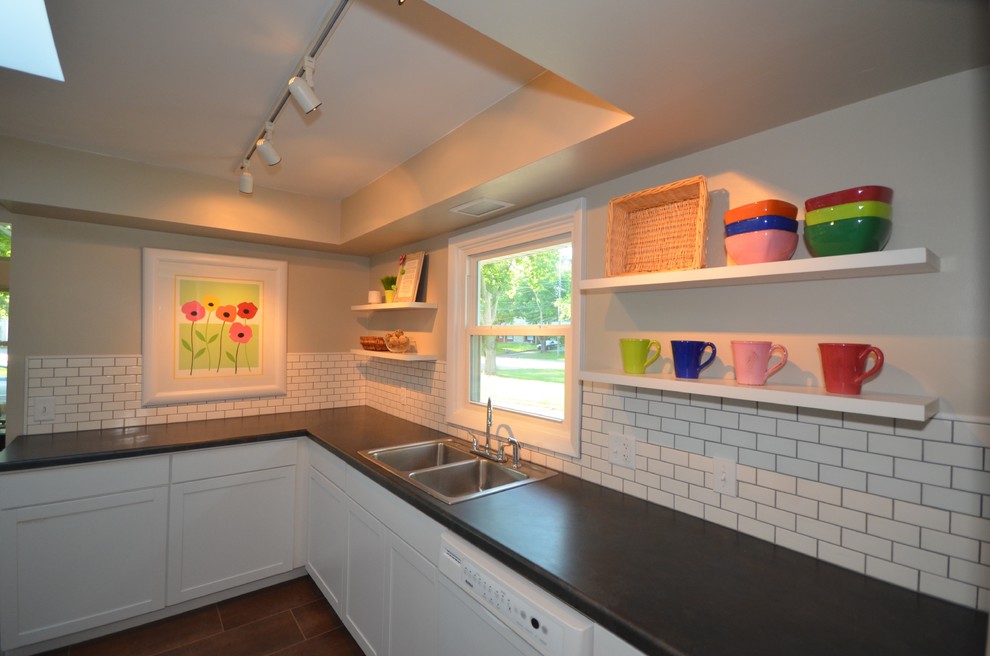 Photo of a mid-sized modern u-shaped separate kitchen in Grand Rapids with a drop-in sink, shaker cabinets, white cabinets, laminate benchtops, white splashback, subway tile splashback, white appliances, ceramic floors and no island.