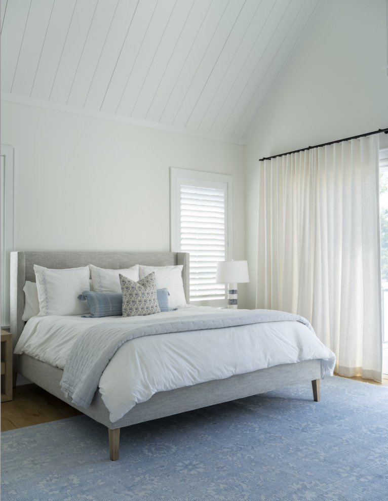 Esempio di un'ampia camera matrimoniale minimalista con pareti bianche, parquet chiaro, pavimento marrone e soffitto in perlinato