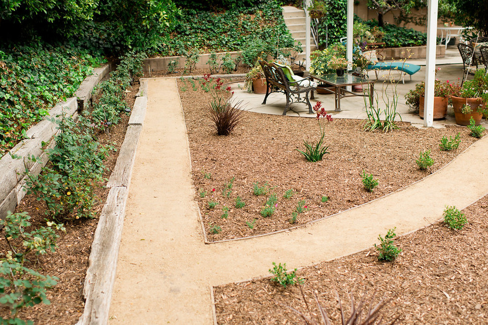This is an example of a mid-sized contemporary backyard partial sun xeriscape for summer in Los Angeles with mulch.