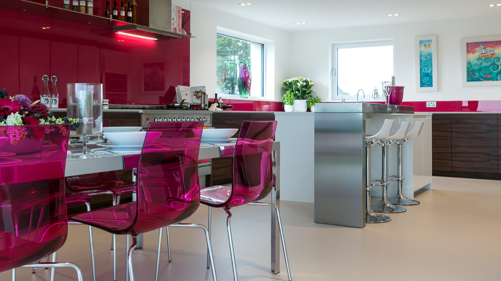Expansive modern u-shaped kitchen in London with an undermount sink, flat-panel cabinets, solid surface benchtops, pink splashback, glass sheet splashback, stainless steel appliances and with island.