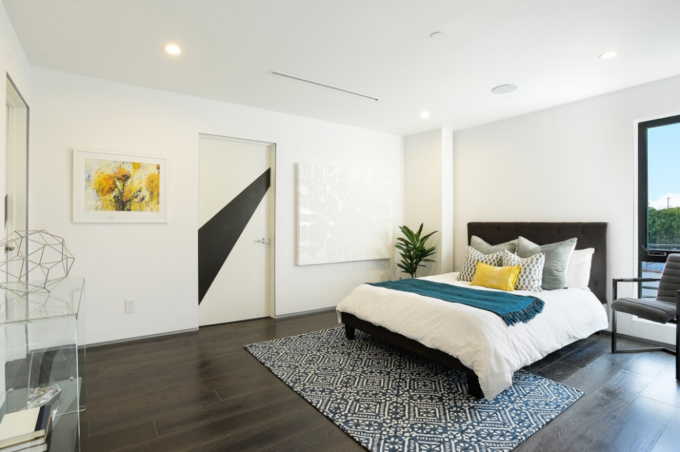 This is an example of a mid-sized modern master bedroom in Los Angeles with white walls, medium hardwood floors, brown floor and no fireplace.