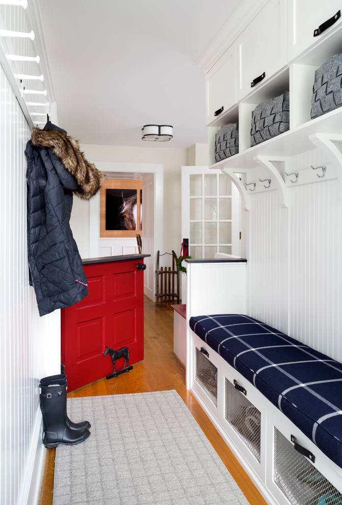 This is an example of a small country mudroom in DC Metro with white walls, medium hardwood floors, a dutch front door and a red front door.