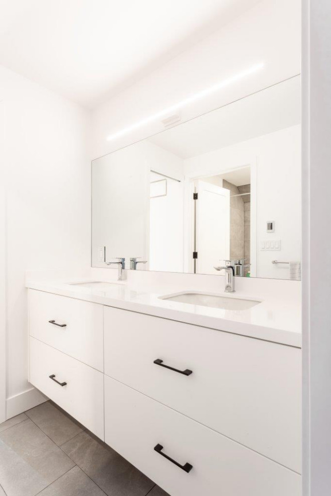 Photo of a large contemporary kids bathroom in Other with flat-panel cabinets, light wood cabinets, an alcove shower, a one-piece toilet, white tile, porcelain tile, white walls, porcelain floors, an undermount sink, engineered quartz benchtops, grey floor, an open shower and white benchtops.
