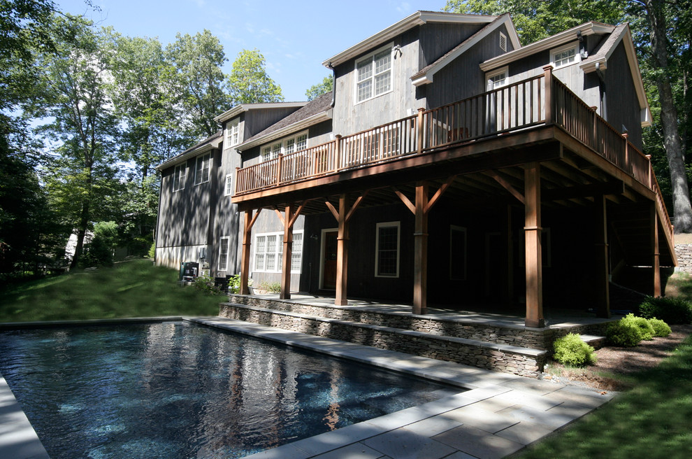 This is an example of a country backyard rectangular pool in New York with natural stone pavers.