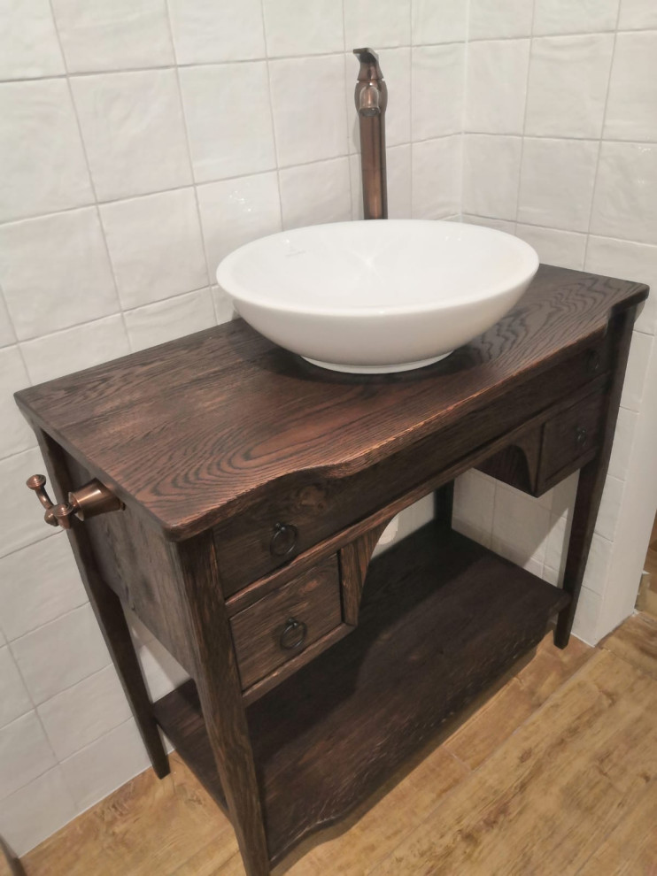 Cette image montre une salle d'eau chalet en bois foncé de taille moyenne avec un placard avec porte à panneau surélevé, un plan de toilette en bois, un plan de toilette marron, meuble simple vasque et meuble-lavabo encastré.