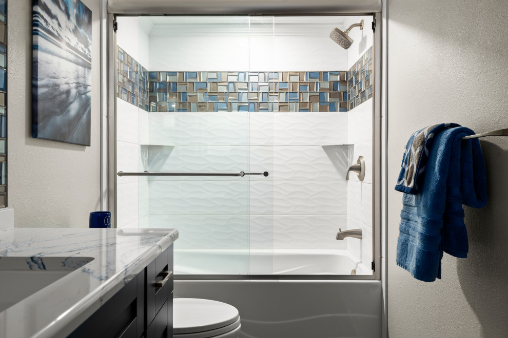 Идея дизайна: маленькая главная ванная комната в морском стиле с фасадами в стиле шейкер, синими фасадами, ванной в нише, душем в нише, унитазом-моноблоком, разноцветной плиткой, керамической плиткой, бежевыми стенами, полом из керамической плитки, врезной раковиной, столешницей из искусственного кварца, белым полом, душем с раздвижными дверями, синей столешницей, тумбой под одну раковину, напольной тумбой и потолком из вагонки для на участке и в саду