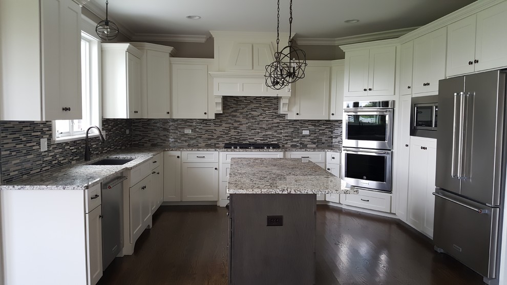Inspiration for a transitional u-shaped medium tone wood floor eat-in kitchen remodel in Chicago with recessed-panel cabinets, white cabinets, granite countertops, stainless steel appliances and an island