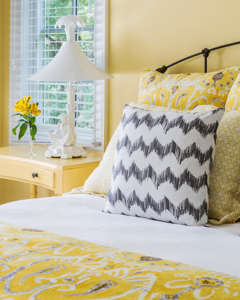 Inspiration for a large transitional bedroom in New York with yellow walls and dark hardwood floors.