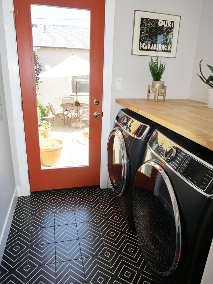 Ispirazione per una piccola sala lavanderia moderna con pareti grigie, pavimento in gres porcellanato, lavatrice e asciugatrice affiancate e pavimento nero