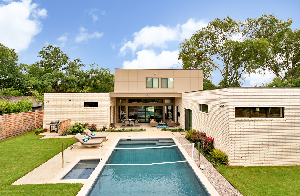 This is an example of a contemporary two-storey brick white exterior in Dallas with a flat roof.