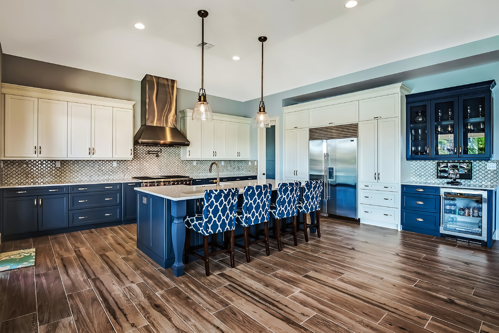 Inspiration for a large transitional l-shaped open plan kitchen in Tampa with a farmhouse sink, shaker cabinets, white cabinets, recycled glass benchtops, multi-coloured splashback, porcelain splashback, stainless steel appliances, porcelain floors and with island.