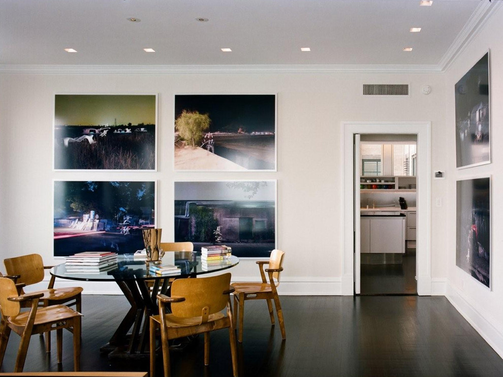 This is an example of a modern dining room in Chicago with beige walls and dark hardwood floors.