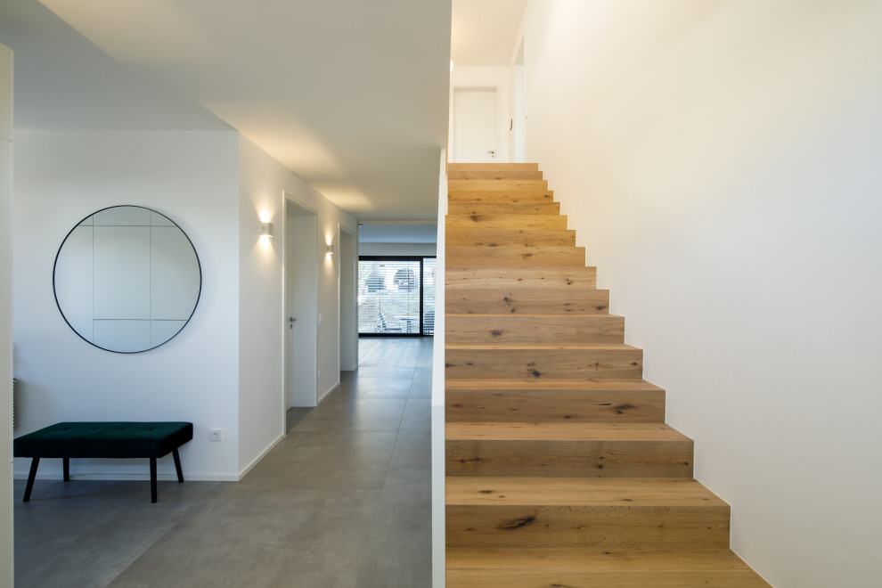 Staircase - mid-sized modern wooden straight metal railing staircase idea in Munich with wooden risers