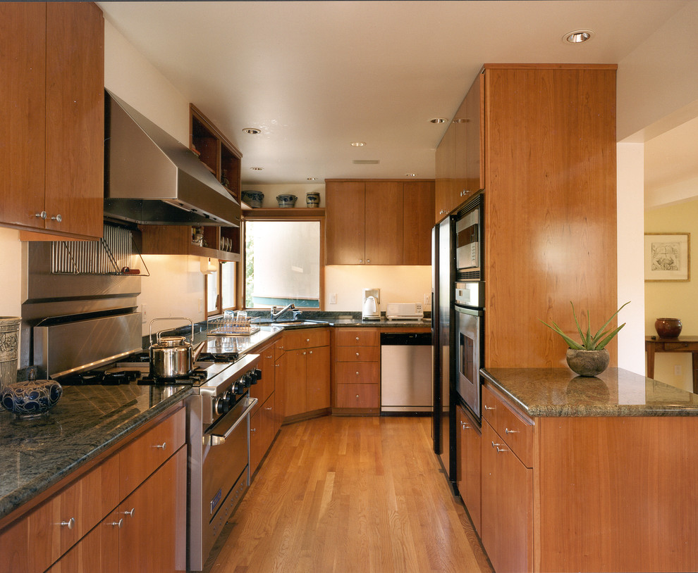 This is an example of a modern galley kitchen in Seattle with stainless steel appliances and granite benchtops.