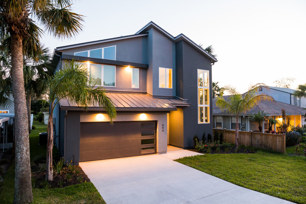 Mid-sized modern two-storey stucco grey house exterior in Jacksonville with a gable roof and a mixed roof.