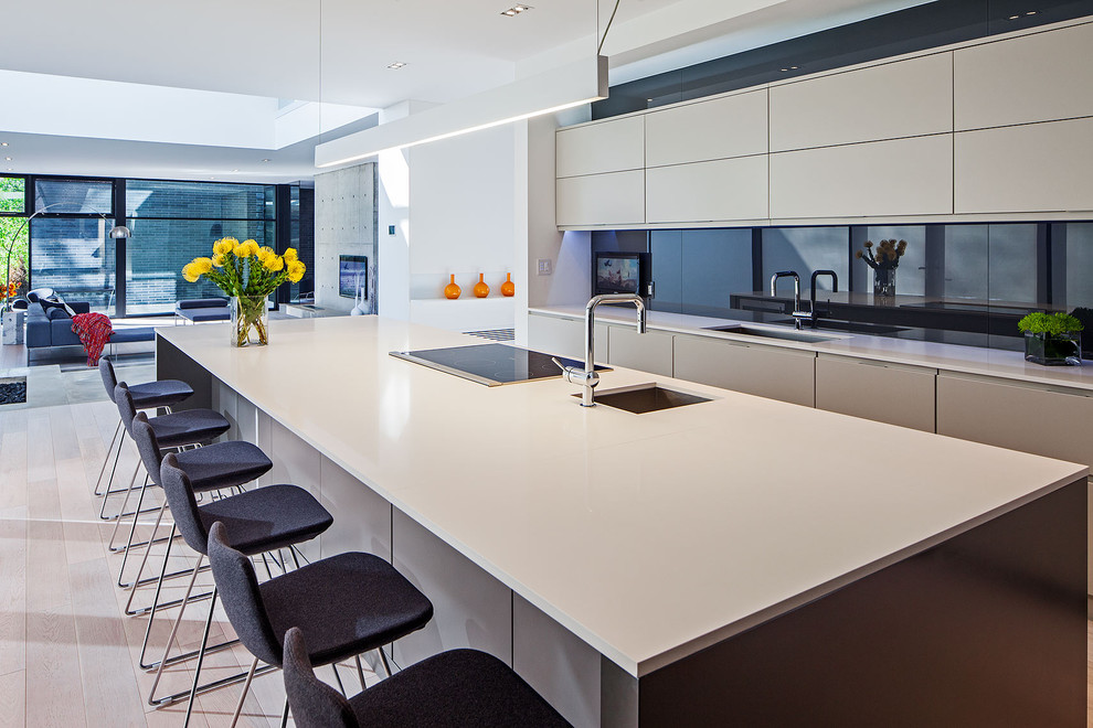 Design ideas for a scandinavian kitchen in Toronto with an undermount sink, flat-panel cabinets, white cabinets, black splashback and glass sheet splashback.