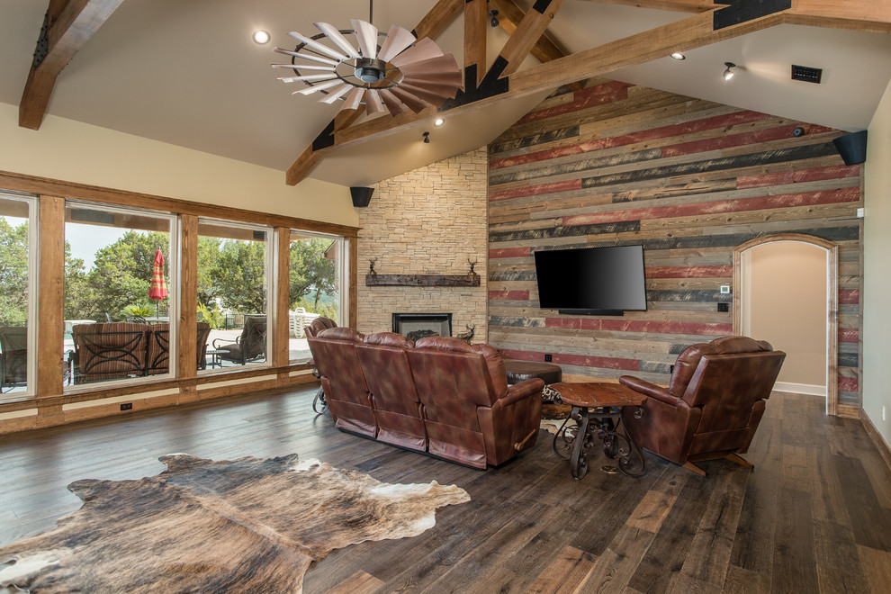 Inspiration for a country formal open concept living room in Other with beige walls, dark hardwood floors, a corner fireplace, a stone fireplace surround, a wall-mounted tv and brown floor.
