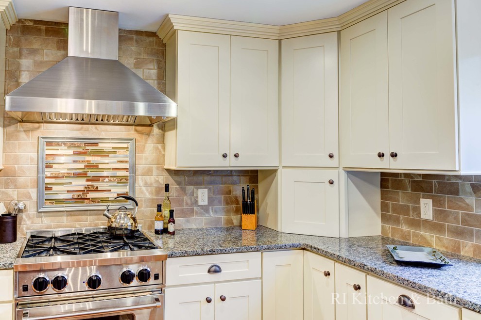 Example of a large transitional u-shaped light wood floor eat-in kitchen design in Providence with an undermount sink, shaker cabinets, beige cabinets, granite countertops, brown backsplash, porcelain backsplash, stainless steel appliances and an island