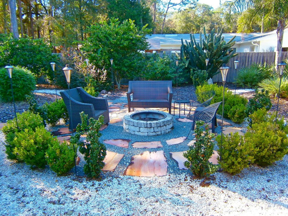 Design ideas for a mid-sized asian backyard full sun xeriscape for summer in Orlando with natural stone pavers and a fire feature.