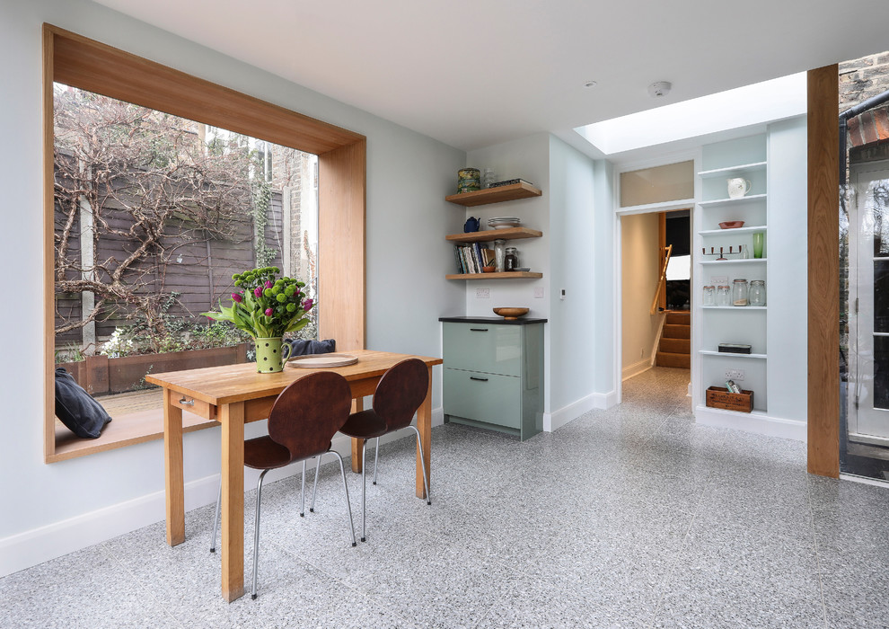 Mid-sized contemporary kitchen/dining combo in London with grey floor and grey walls.