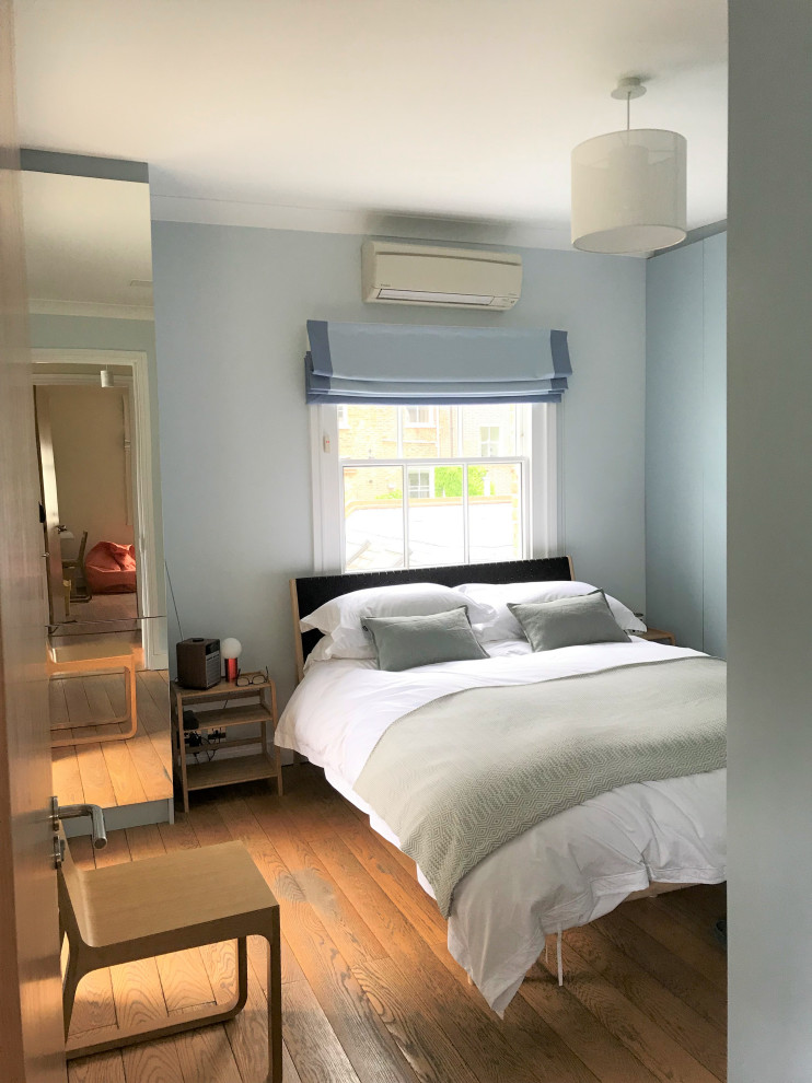 ロンドンにある中くらいな北欧スタイルのおしゃれな寝室 (無垢フローリング、青い床) のインテリア