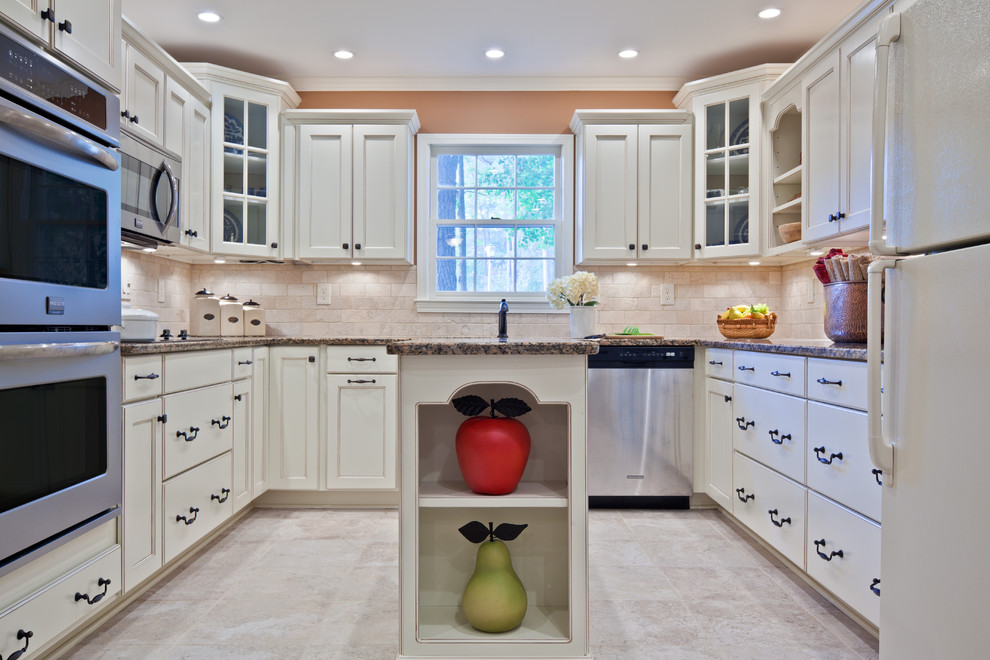 Inspiration for a mid-sized traditional u-shaped eat-in kitchen in Atlanta with white cabinets, beige splashback, stone tile splashback, stainless steel appliances, an undermount sink, recessed-panel cabinets, granite benchtops, porcelain floors, with island, beige floor and brown benchtop.