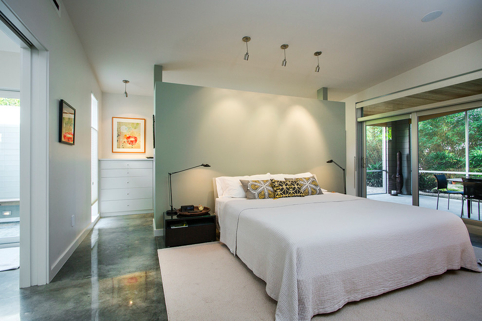 Design ideas for a midcentury master bedroom in Tampa with white walls and concrete floors.