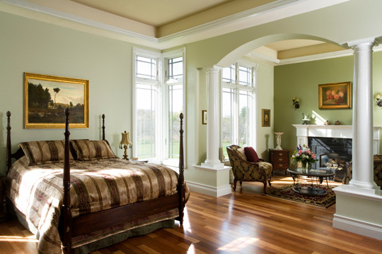 Пример оригинального дизайна: большая хозяйская спальня в классическом стиле с разноцветными стенами, паркетным полом среднего тона, стандартным камином и фасадом камина из штукатурки